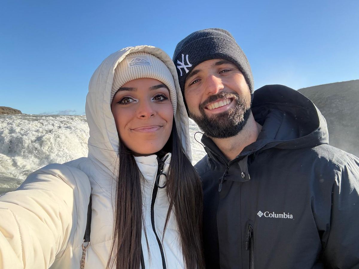 Clara y Diego abrigados frente a una cascada